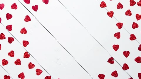 Vlentine's Day composition. Heart shaped sequins placed on white wooden table Stock Footage 228680778