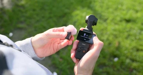 Vlogger Hands Pairing DJI Osmo Pocket 3 With Wireless Mic Mini Video stock 322208291