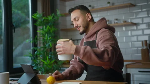 Vlogger man in an apron talking into tablet computer webcam, recording vide.. Stock Footage 263855281