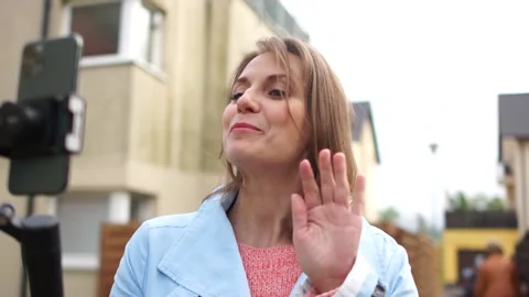 Vlogger with mobile phone camera stabilizer recording outdoor video blog. Live Stock Footage 132520603