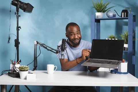 Vlogger presenting and testing laptop Stockfoto's