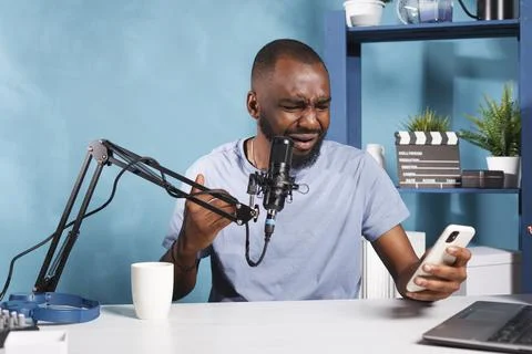 Vlogger reading negative feedback Foto stock