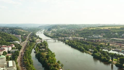 Vltava river flows through green Prague cityscape with highway and bridges 動画素材 341345018
