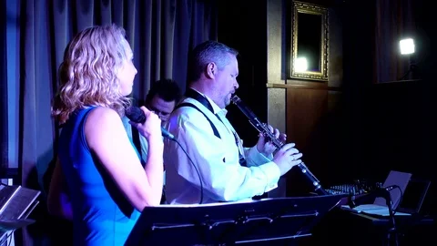 The vocal group. A singer with a microphone and a saxophonist. Stock Footage 83824759