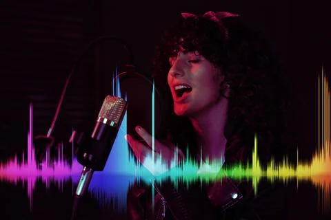 Vocalist singing into microphone in professional record studio. Sound waves Stock Photos