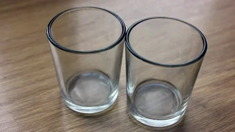 Vodka is being poured into shot glasses at home Видео 123712312