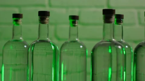 Vodka bottles stand against a brick wall Stock Footage 185191698