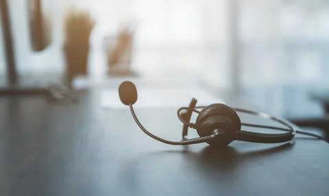 VOIP headset of customer support phone operator at workplace on desk. Stock Photos