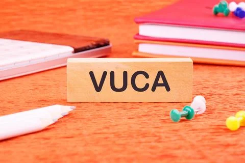 Volatility Uncertainty Complexity Ambiguity. VUCA text on a wooden bar in fro Stock Photos