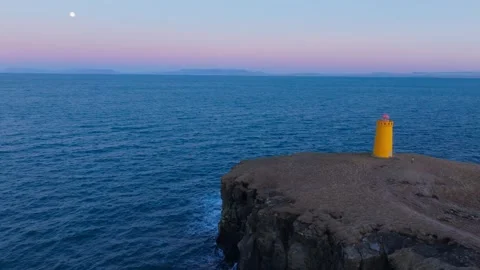 Volcanic basaltic cliffs and vast ocean horizon captured from a high altitude - Stock Footage 330895454