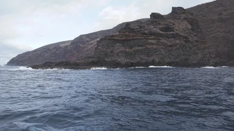 Volcanic cliffs towering over deep blue Atlantic waters, exposing dramatic 스톡 동영상 308414030