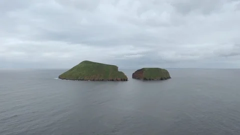 Volcanic dual islets in the ocean under cloudy sky. Aerial of Terceira island Stock Footage 121270063