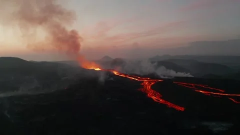 Volcanic Eruption Flowing Lava Streams Across Dark Jagged Volcanic Terrain Stockbeeldmateriaal 331043746