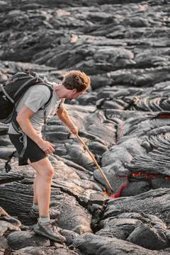 Volcanic eruption Hawaii volcano hike adventure guided tour. Man poking lava Stock Photos