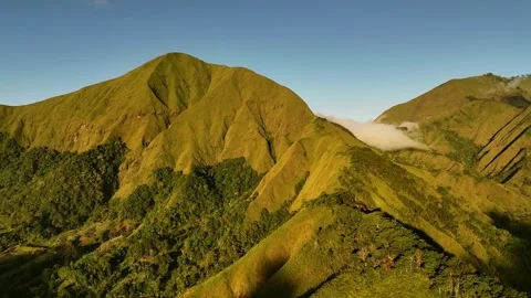 Volcanic Mountain Ridge Framed by Clouds and Lush Forest Stock Footage 342843487