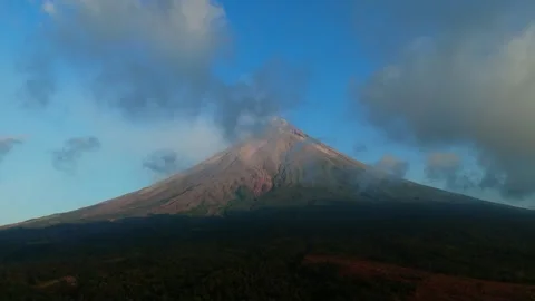 Volcanic peak emits wispy smoke against a bright sky. Vídeos de archivo 333684178