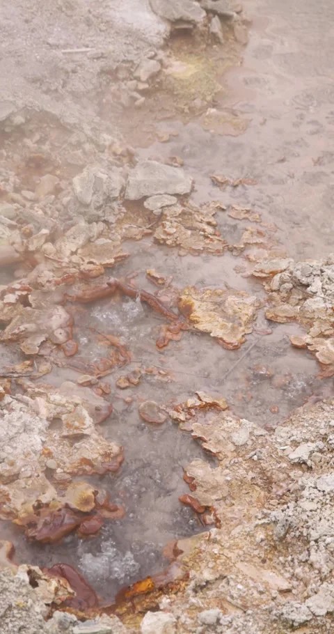 Volcanic pit with mud and boiling water with steam rising to the surface in.. Stock Footage 329618472
