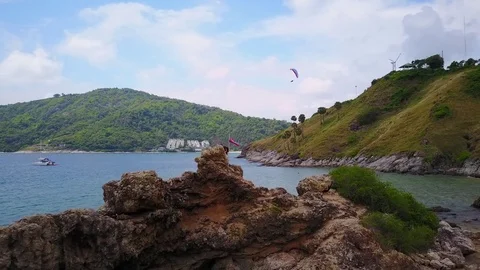 Volcanic rock against sea and heandland at south-west shore of Phuket Island Stock Footage