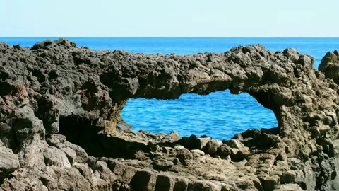 Volcanic rock arch in front of the blue Atlantic Ocean. Stock Footage 169594527