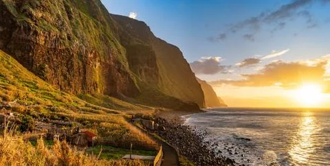 Volcanic rock cliffs Achadas da Cruz in sunlight. Sunset seascape of Madeira Stock Photos