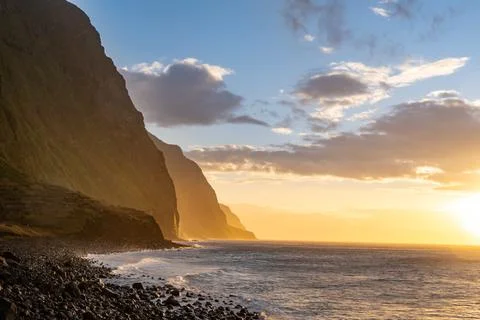 Volcanic rock cliffs Achadas da Cruz in sunlight. Sunset seascape of Madeira Stock Photos