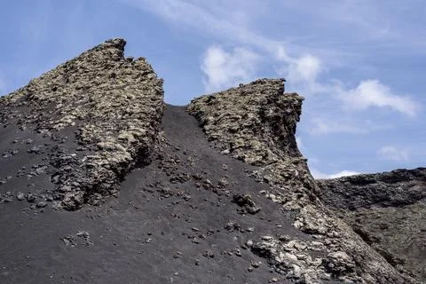 Volcanic rock formations creating a dramatic landscape under blue sky Stock Photos