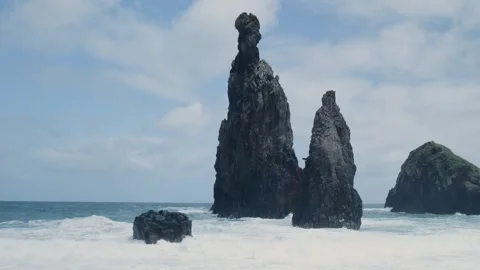 Volcanic rock formations standing strong against crashing ocean waves Vídeo Stock 333695423