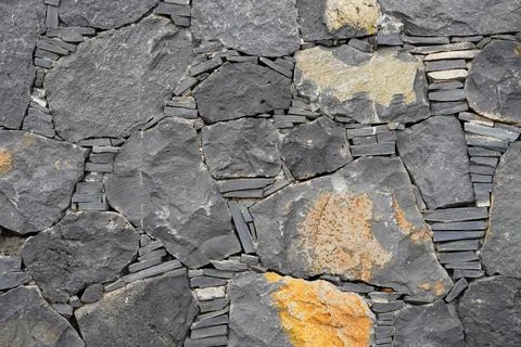 Volcanic rock wall texture with dry stone masonry Stock Photos