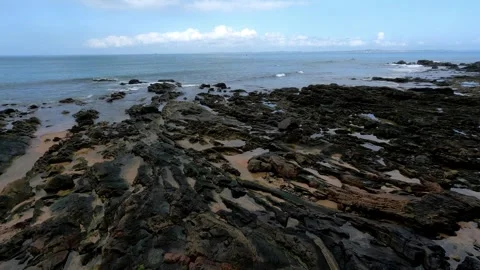 Volcanic Rocks on the Beach: A Dramatic Coastal Landscape Stock Footage 296100323
