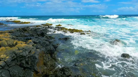 Volcanic rocks on beach with ocean waves. Calm waves slowly overlaying rocks Video stock 212499201