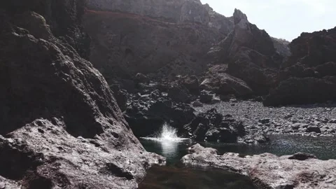 Volcanic rocks framing powerful ocean waves breaking against rocky La Palma Stock Footage 308396621