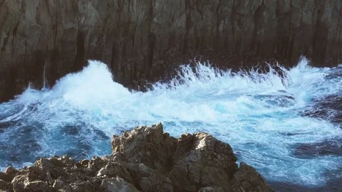 Volcanic vertical cliff and waves breaking Stock Footage 83807992