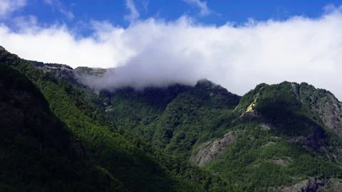Volcano covered by clouds against blue sky Stock Footage 308577008