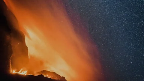 Volcano erupting at night under a starry sky Vídeos de archivo 332961987