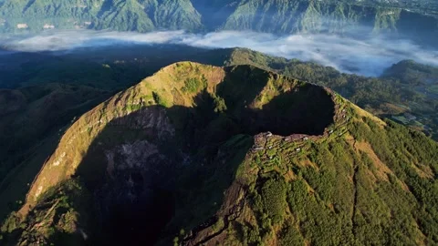 Volcano Highlands with Shadowed Crater and Golden Sunrise Across Misty Bali Vidéo 336704733
