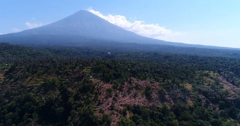 Volcano with its side covered in tropical vegetation, hill at the bottom Stock Footage 114576593
