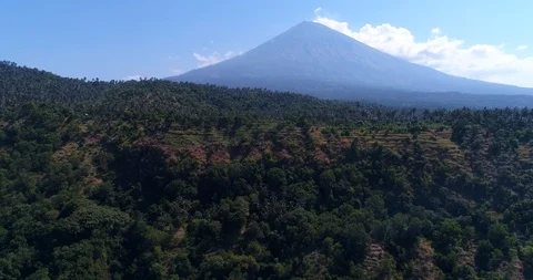Volcano with its side covered in tropical vegetation, hill at the bottom Video stock 114577680