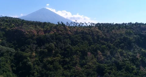 Volcano with its side covered in tropical vegetation, hill at the bottom Video stock 114577773