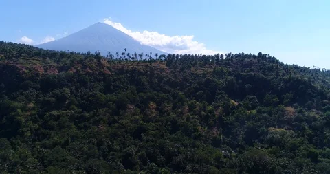 Volcano with its side covered in tropical vegetation, hill at the bottom Stock Footage 114580542