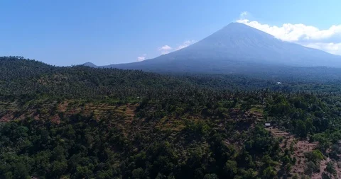 Volcano with its side covered in tropical vegetation, hill at the bottom Stock Footage 114584305