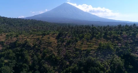 Volcano with its side covered in tropical vegetation, hill at the bottom Video stock 116058182