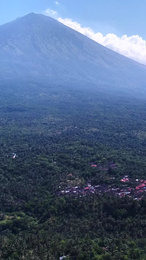 Volcano with its side covered in tropical vegetation, village at the bottom Stock-Footage 230284426