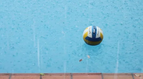 Volleyball floating on a pool raining Stock Footage 974911
