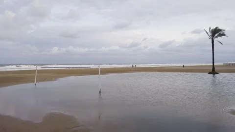 Volleyball net surrounded by puddle on Cullera Beach after heavy rain Stock Footage 318746306