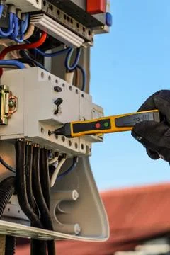 Voltage control in switchboard with special detector. Work of the electrician. Stock Photos