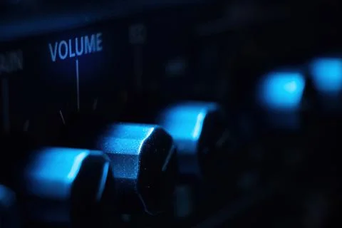 Volume knob on aplifier with cool blue light in macro view Stock Photos