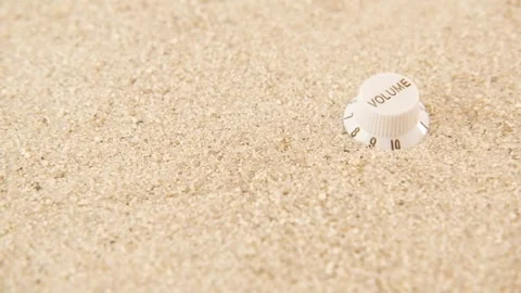 Volume knob isolated on bright sand rotating Stock Footage 246407142