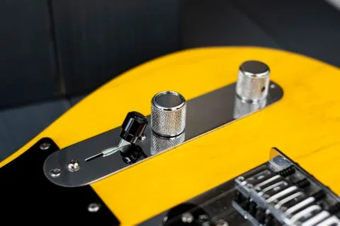 Volume, tone and switcher controls of a classic yellow and black electric gui Stock Photos