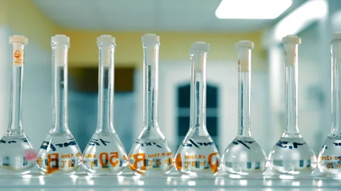 Volumetric Flasks in Science Lab. Row of volumetric flasks with clear liquid in Stock Footage 260477725