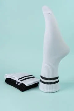 Volumetric sock and stack of white and black socks with stripes. Stock Photos